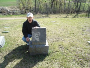 Jeff Gulleson behind Cecelia Gulleson's (Mother of Edward Gulleson) Grave Stone in the Gulleson Family Cemetery Plot, Lutheran Church Cemetery in Vining, MN.